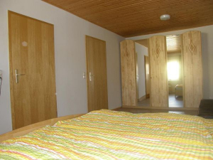 Schalfzimmer für 3 Personen mit einem 5-türingen Kleiderschrank. Die linke Tür führt zu einem WC mit Waschbecken und durch die rechte Tür gelangen Sie wieder in das Wohnzimmer.
