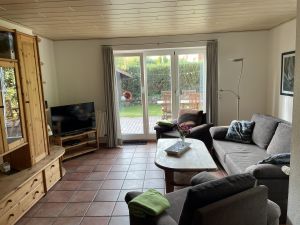 Sitzgarnitur mit bequemer Schlafcouch. Zugang zu Garten und Terrasse.