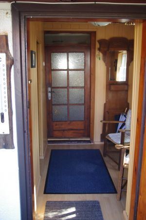 Garderobe mit kleiner Sitzgelegenheit,
links geht es in die Veranda.