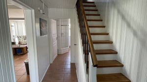 Blick von der Haustuer in Richtung Treppe. Links befindet sich der Wohnraum, geradeaus das Bad.