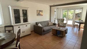 Wohnzimmer mit offener Küche und Essecke und Zugang zur Terrasse
