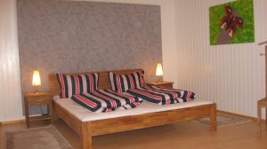 Hier sehen Sie eines der 2 Schlafzimmer. 1 x mit 180er Bett, 1 x mit 140er Bett. Beide Schlafzimmer haben Terrassenelemente. Sie kommen direkt auf die untere Terrasse und dem Garten. Wer hat das schon? Das Duschbad mit begehbarer grosser Dusche befindet sich im Mittelgeschoss.