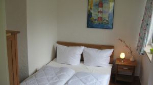 Hier sehen Sie das kleine Schlafzimmer mit dem 140er Bett, welches auch mit einem TV ausgestattet ist. Das Haus hat insgesamt 3 Schlafzimmer. 2 x mit 180er Doppelbetten im Souterrain und 1 x in der Paterre mit einem 140er Bett. Es ist also Platz für maximal 6 Personen. Bedenken Sie dann aber, dass nur 1 Duschbad zur Verfügung steht.