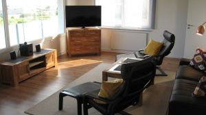 Auch vom gemütlichen Wohnzimmer aus im Sitzen können Sie das Meer geniessen. Gleichzeitig blicken Sie auf den TV. 2 Relaxsessel mit Fußhockern machen die Sache perfekt.