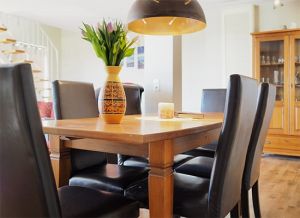 Zum Speisen oder Spielen lädt ein ausziehbarer Esstisch ein. Der Wohnraum ist mit Laminat-Boden und einigen Teppichen ausgestattet.
Über eine bequeme Treppe erreichen Sie das Obergeschoss mit seinen Schlafräumen sowie einem zweiten Duschbad.