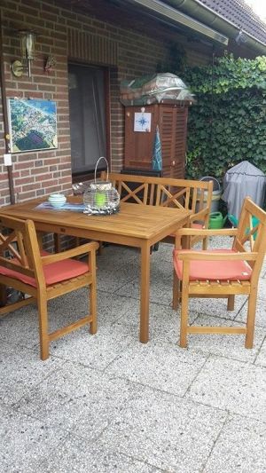 Terrasse mit Marquise, Grill, Gartenmöbeln und Blick ins Grüne.
