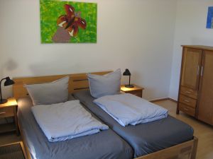 Eines der beiden Schlafzimmer mit 180er Doppelbett und Ausgang zum Garten