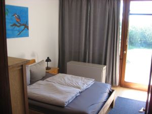 Eines der beiden Schlafzimmer mit 140er Bett und Ausgang zum Garten