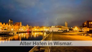 Der alte Hafen von Wismar bei Nacht ist ein magischer Anblick. Die alten Gebäude entlang des Hafens werden von der Dunkelheit umhüllt, während das Wasser des Hafens vom Licht der Laternen und Boote erhellt wird.