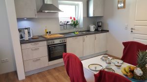 Tisch mit 4 Stühlen und komplett eingerichtete Einbauküche