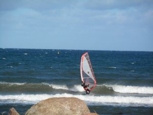 Surfer Bei Sturm sind viele Surfer zu beobachten. Drachen werden in die Luft geschickt.