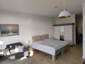 Wohn-/Schlafbereich und Kleiderschrank Ein 2-Sitzer Sofa, zwei zusammen stehende Einzelbetten mit getrennten Matratzen (je 200 x 90 cm) und ein geräumiger Kleiderschrank.
